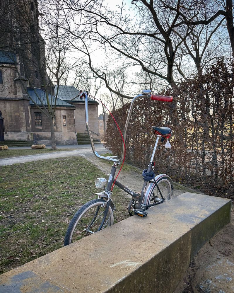 Mein graues MiFa Klappfahrrad mit extra hohem Lenker von rechts vorn betrachtet